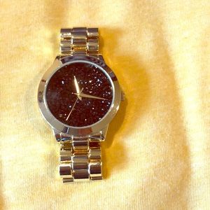 Gold colored watch with black crystal detail back